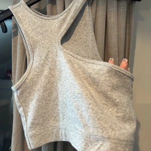 Snygg grå topp - Xs  Grå topp med detaljer från Nelly.com Använder inte 