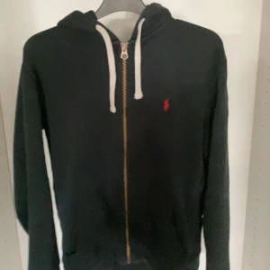 Polo Ralph Lauren Zip Hoodie - Börjar bli ett litet hål i ena tröjärmen men annars är den i gott skick. Kan skicka bild på ärmen om det önskas. 