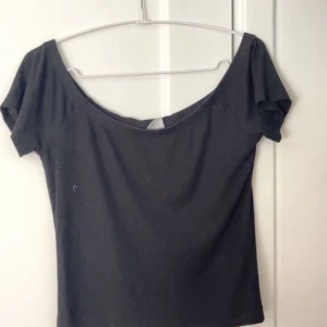 Svart T-shirt  - Svart kroppad T-shirt ifrån Gina Tricot. Stretchigt material. Funkar både som en vanlig T-shirt men även som off-shoulder