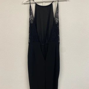 Jumpsuit - Lång jumpsuit. Öppen rygg med spets. Fint skick.