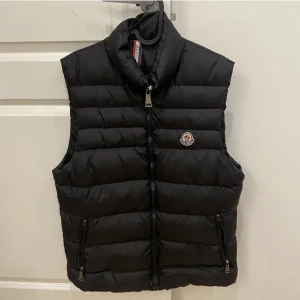 Moncler väst - Moncler Väst Svart moncler väst i perfekt form som ny använd ett par gånger bara. Storlek 2 som jag tror betyder Medium men borde funka för small också. Säljs för 2700 men pris kan diskuteras perfekt till  vinter och hösten