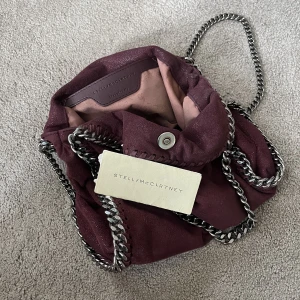 Stella McCartney Falabella Mini Röd - Nu är det dags att sälja min Stella McCartney väska eftersom jag har tröttnat på den😅 Äkthetsintyg finns och den är lite smutsig inuti som visas på bilden men inget som inte går att tvätta bort!   Obs: jag byter inte!