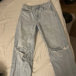 Byxor från Gina  - Blåa byxor med hål på knä från Gina, andvända väldigt fåtal gånger, är i fint skick 