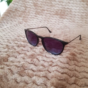 Solglasögon - Svarta solglasögon med silverbågar. Svart-blå glas.