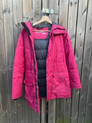 Rosa vinterjacka från Everest - Rosa vinterjacka från Everest, storlek 34. Luva med fluffig kant och många smidiga fickor samt innerficka. Har använts men fortfarande i gott skick!    Vid fler funderingar är det bara att fråga!