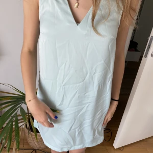 Ljus turkos klänning  - En riktig sommarklänning i en sååå härlig färg! Notera att den har en väldigt hög slits, skulle rekommendera att antingen sy igen den lite eller använda som strandklänning. Helt ny med lappen kvar, nypris är 299kr.