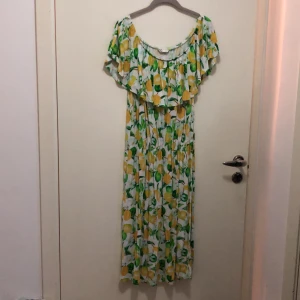 Mönstrad klänning - Citronmotiv. Stretchig! Går att ha som off shoulder eller på axlarna. Lite små nopprig på vissa ställen men i övrigt hel och fin.