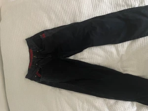 Baggy jeans med röda detaljer - Har ett litet hål i ena benet men det syns inte så mycket. 