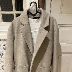 Beige höstkappa - Funderar på att sälja denna fina beigea höstkappan från Gina Tricot. Den är inte använd särskilt mycket, säljer bara då jag tycker den är lite stor i axlarna på mig!