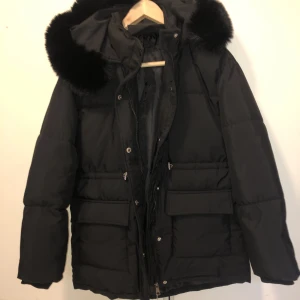 Svart vinterjacka  - Så snygg helt ny svart vinterjacka. Strl S. Dragsko i midjan. Härlig luva med avtagbar päls.