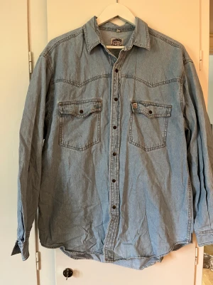 Jeansskjorta L - En retro jeansskjorta i storlek L. Funkar för en M om man vill ha lite ”oversize”
