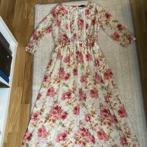 Lång sommarklänning-Forever 21 - En vit och rosa lång sommarklänning, med blommor på. Med brodering framtil, väldigt sval på sommaren man passar också till en finare middag! 