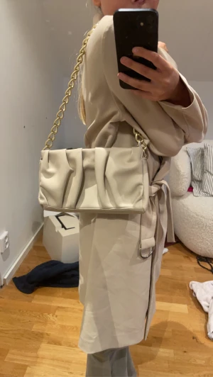 Beige väska - Säljer denna beiga axelremsväskan som är köpt på MQ men märket är stockh LM den är i bra skick och använt fåtal gånger💕