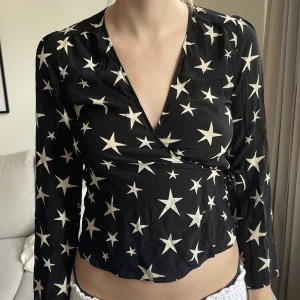 Blus Realisation Par strl M - Svart blus med stjärnor från Realisation Par i 100% silke. Omlott blus som knyts. Endast använd 1-2 gånger så är i nyskick! Kan upplevas lite mindre i storleken. Nypris ca 1500kr