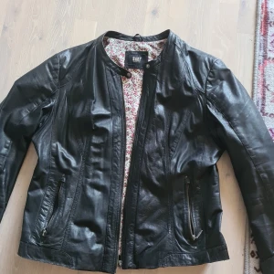 Skinnjacka  - Svart skinnjacka med blommigt foder. Använd men felfri