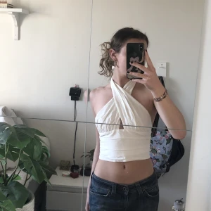 Vit festlig halterneck topp🌸 - Säljer denna vita halternecktoppen i lyxigt material från Gina tricot, storlek 34 och är endast använd vid ett tillfälle, säljs inte längre🪸💕