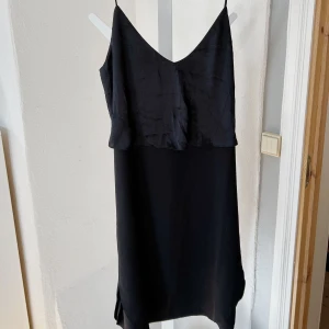 Klänning  - En svart lite tunnare klänning med en litet extra lager i siden. 