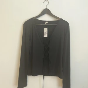 Svart lace up top - Från Nelly, aldrig använd  Passar M/L