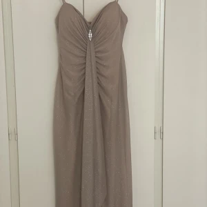 Lång festklänning  - Använd 1gång, passar fint för bal och fester. Storlek M, färgen beige med glans i super fin. Priset kan diskuteras :kr 