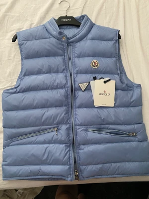 Blå Moncler gui väst  - Hej säljer nu min ljus Blåa Moncler väst stl L passar även M unisex både till killar och tjejer, hör av er för fler bilder 💗
