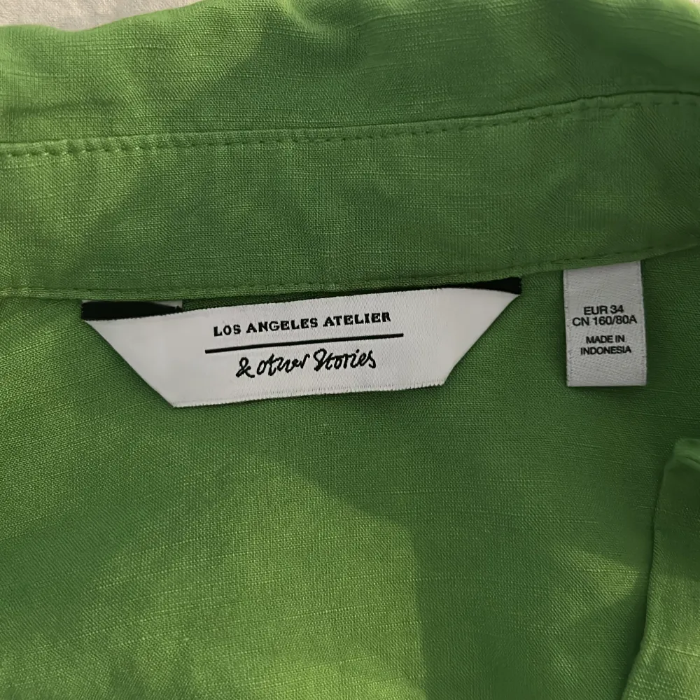 Croppad grön skjorta med knyte för bättre passform. Nyskick, aldrig använd.. Blusar.