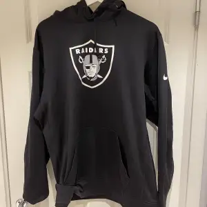 Svart Nike hoodie med Raiders-logo på bröstet och Nike-logo på ärmen. Använd skick. Typ tech-fleece material.