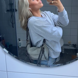 Grå handväska - Säljer en snygg grå handväska med kedjor, den kan va dubbelvikt som på bilden eller crossover ❤️❤️💓