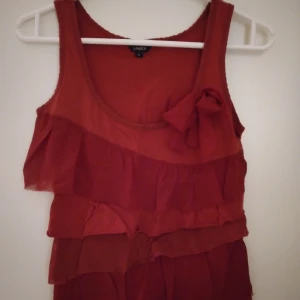 Röd ärmlös topp / linne med volanger och rosett. XS. Bomull. Lindex. - Röd ärmlös topp / linne med volanger och rosett. XS. Bomull. Lindex.