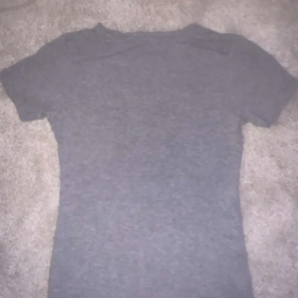 Säljer denna gråa V ringade  Ralph Lauren t-shirten som inte kommer till användning längre. Inga defekter och är i storlek S men passar även som xs!!🥰 . T-shirts.