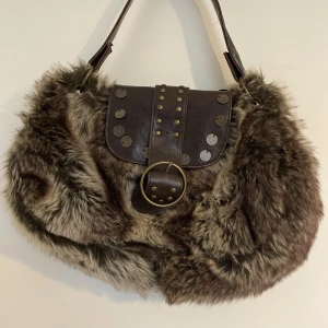 Pälsväska med coolt spänne - Helt oanvänd pälsväska i mellan storlek. 