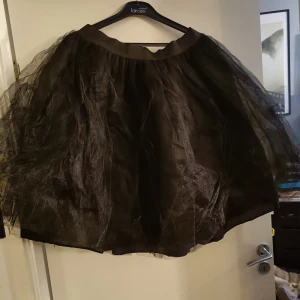 Svart tyllkjol  - Tre lager tyll över innerkjol. Ca 60cm lång, resår i midjan. Aldrig använd.