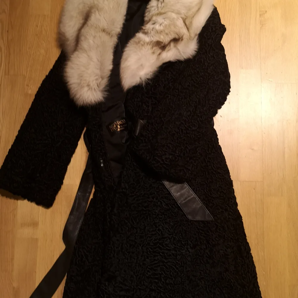 En svart kappa med snygga detaljer. Tillverkad i Göteborg. Äkta. Riktigt snygg. Varm och skön att ha på sig. . Jackor.
