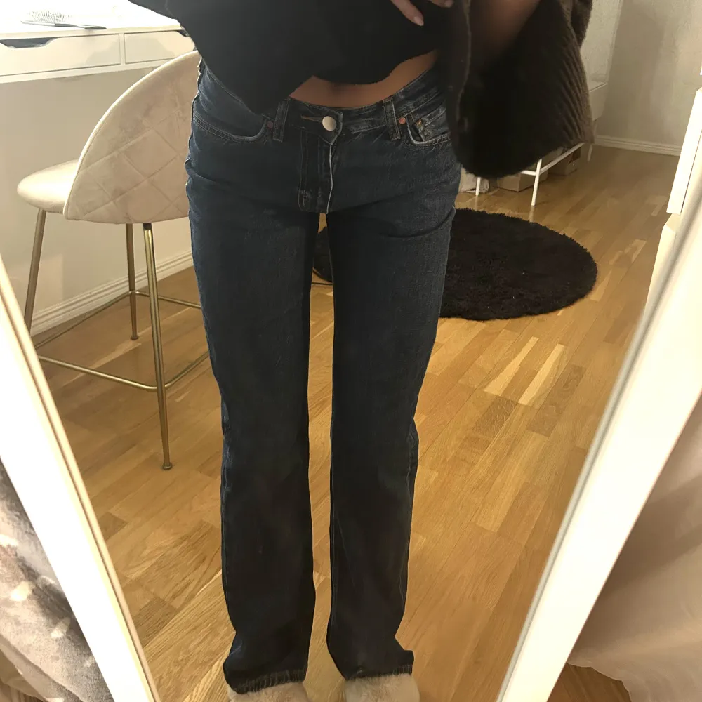 Säljer dessa mörkblåa jeans från BikBok 😍 Dom är low waist och i storlek W26 L32 (se sista bilden). Är jättebra längd för mig som är 170 och sitter perfekt i midjan! 🙏 Enadst använda ett fåtal gånger!. Jeans & Byxor.