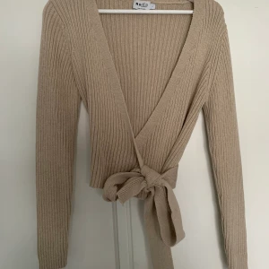 Stickad omlott tröja - Stickad omlott tröja från NAKD, storlek L. Sparsamt använd. (Köparen står för frakt).