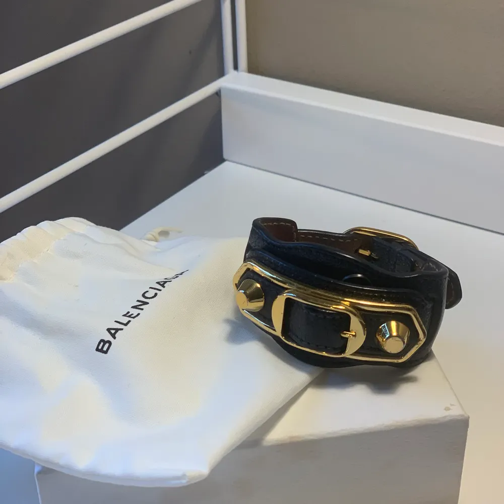 Ett mörkblått Balenciaga armband med gulddetaljer inköpt 2018 i Paris. Dustbag tillkommer vid köp. Armbandet är använt ett få tal gånger och är i mycket fint skick. Säljes för 600 kr.. Accessoarer.