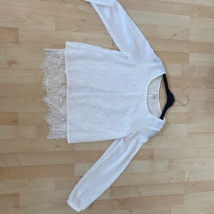 Vit blus strl xs - passar s - En vit blus från New Yorker strl xs men passar även s. Fint skick, använd fåtal gånger. ”Slits” i ryggen där man ser lite av ryggen genom spetsen. Kan fraktas om köpare betalar frakt. Hund finns i hemmet!