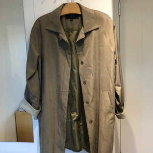 Trenchcoat i fakemokka - Grön jacka! Superskönt material, fungerar både på vinter med en tjockare tröja under och på vår och höst💛 hör av er om ni har frågor