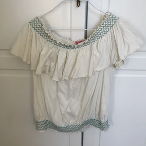 Mjuk off shoulder-blus - Toppskick! Strl S från Indiska. Otroligt mjuk, luftig & skön gräddvit blus. Resår med turkosa stygn uppe & nere. Går att använda ”ovanpå” axlarna också, det brukade jag göra.