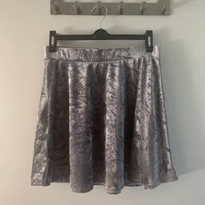 Sammetskjol från Monki - Kjol ifrån Monki i silverfärgad krossad sammet. Fin och bekväm! I bra skick. Storlek S.  