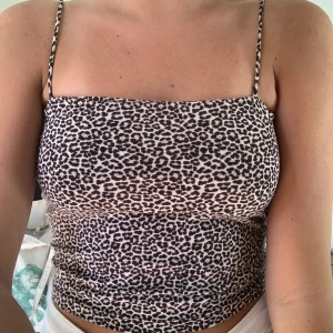 Leo Topp - Leopard topp från Ginatricot, finast skick och är använd en gång. Tunna axelband (ej justerbara) Croppad modell men går nedanför naveln.