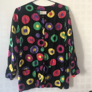 Retroblus i härligt mönster - Den här införskaffades second-hand för två år sedan. Varje gång jag har på mig den får jag beröm. Mönstret är oemotståndligt. Storlek står inte men den passar alltifrån stl S-L. Passar till kjol och byxor på fest eller till vardags.