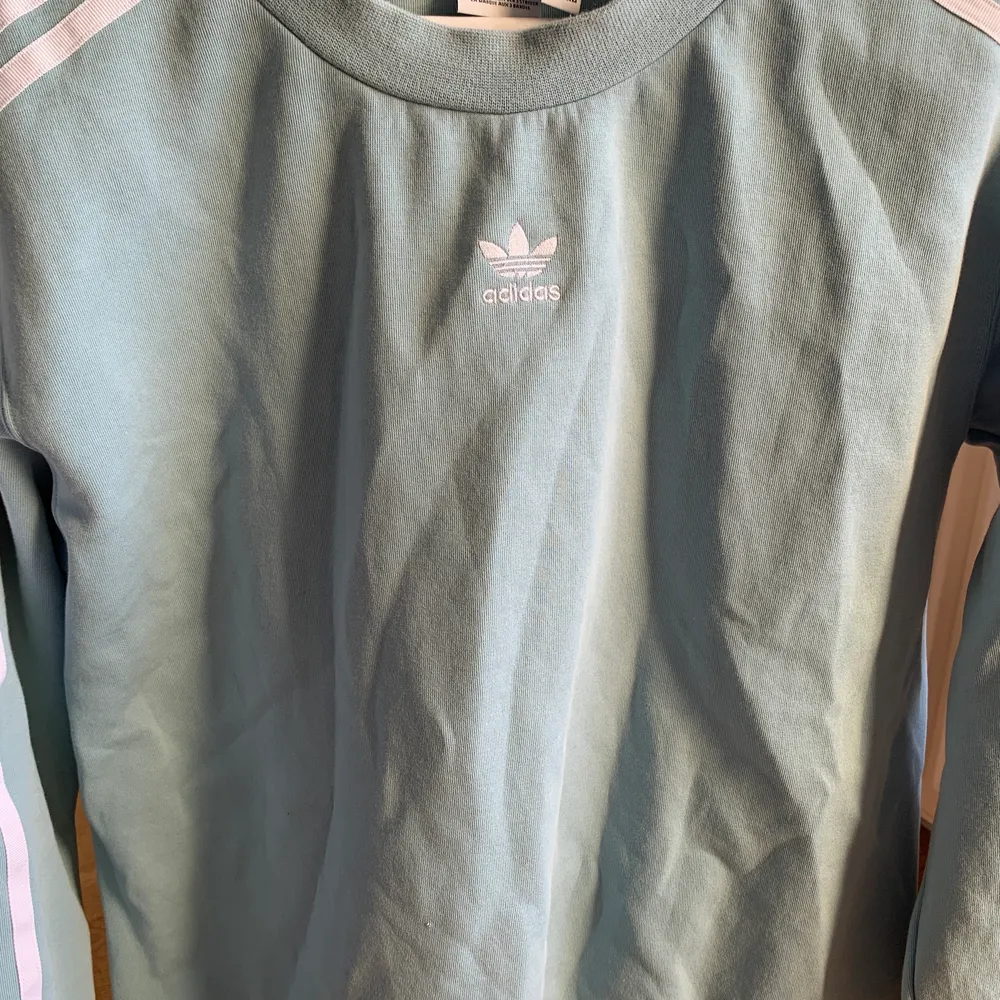 Adidas sweatshirt i en härlig turkosblå färg. Inköpt från Zalando för ca 2 år sedan, men endast använd ca 5-10 ggr. Säljer pga att den inte används! NYPRIS: 799kr. Hoodies.
