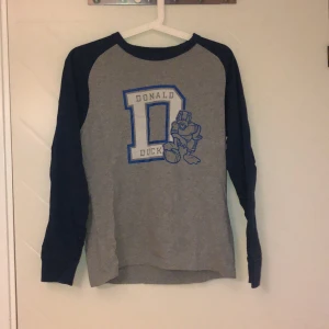 Uniqlo Donald Duck långärmad strl S - Käck långärmad tröja från Uniqlo, aldrig använd! Snygg på såväl tonår som barn. Tidlös!