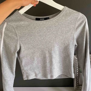  - Croppad grå långärmad med vita streck på armarna från BikBok. Mycket bra skick och skön passform. Stretchiga och mjuk. Hör av dig vid frågor. Buda på om fler är intresserade.