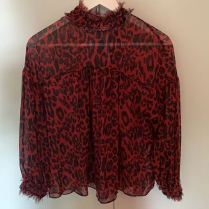 Leopardblus - Blus från zara i ett rött svart leopard print som är lite genomskinligt.Knappt använd. Köparen står för frakten. 