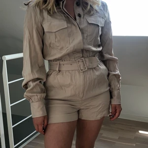 Beige cargo jumpsuit från H&M - Säljer denna cargo jumpsuit ifrån H&M. Aldrig använd och lappen finns fortfarande på. Nypris är 400! Skriv vid frågor.