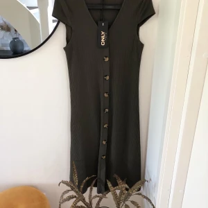 Only klänning  - Söt grön knälång klänning med träknappar från Only i storlek M. NY med tagg! Nypris 399kr