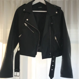 Skinnjacka - Kort skinnjacka från pull & bear. Använd men i bra skick, den har ett litet märke bak på vänstra axeln, dock inget som märks. Stl m men skulle säga att den är mer en s. Ej äkta.