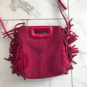 Maje väska - Säljer den super coola och snygga väskan från Maje. Den har några få defekter men inget som syns särkilt tydligt. Jag har även gjort ett till hål i bandet då jag tyckte att den var lite för lång för mig. Säljer den på grund av att den inte kommer till användning längre💓💓nypris var ungefär 2300kr, köparen står för frakten🥰