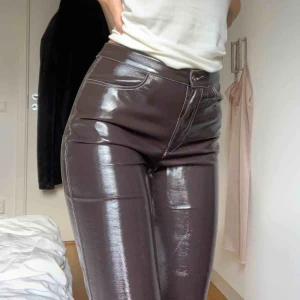  - Sjukt snygga brun/lila lackbyxor från Carin Wester med vita sömmar. Lite utställda längst ner och kort i modellen. Använda men i väldigt bra skick, nästintill nyskick. Säljer pga för korta för mig som är 174 cm. Nypris 500kr. 